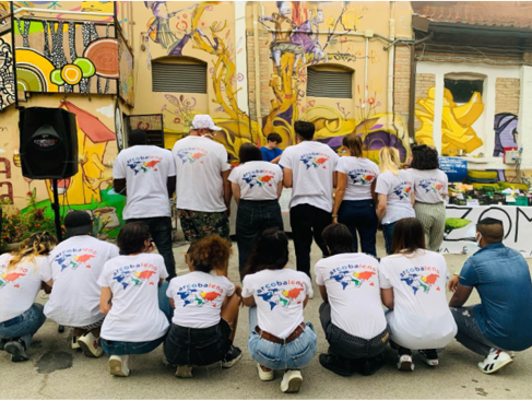 Gruppo di volontari di spalle tutti con la t-shirt dell'associazione Arcobaleno