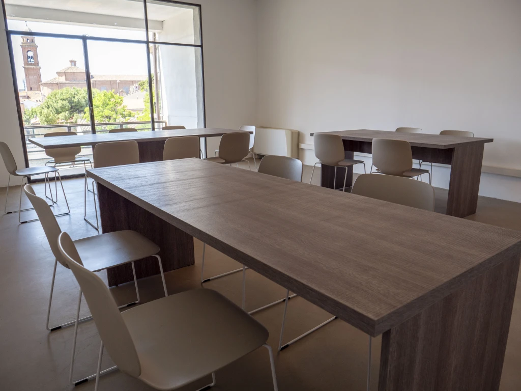 Un tavolo circondato da sedie per il coworking al Laboratorio Aperto di Rimini