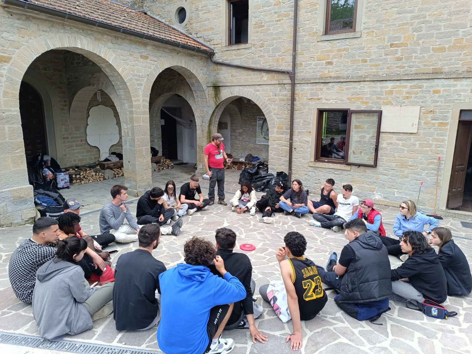 Ragazzi ed educatori seduti in cerchio in campeggio