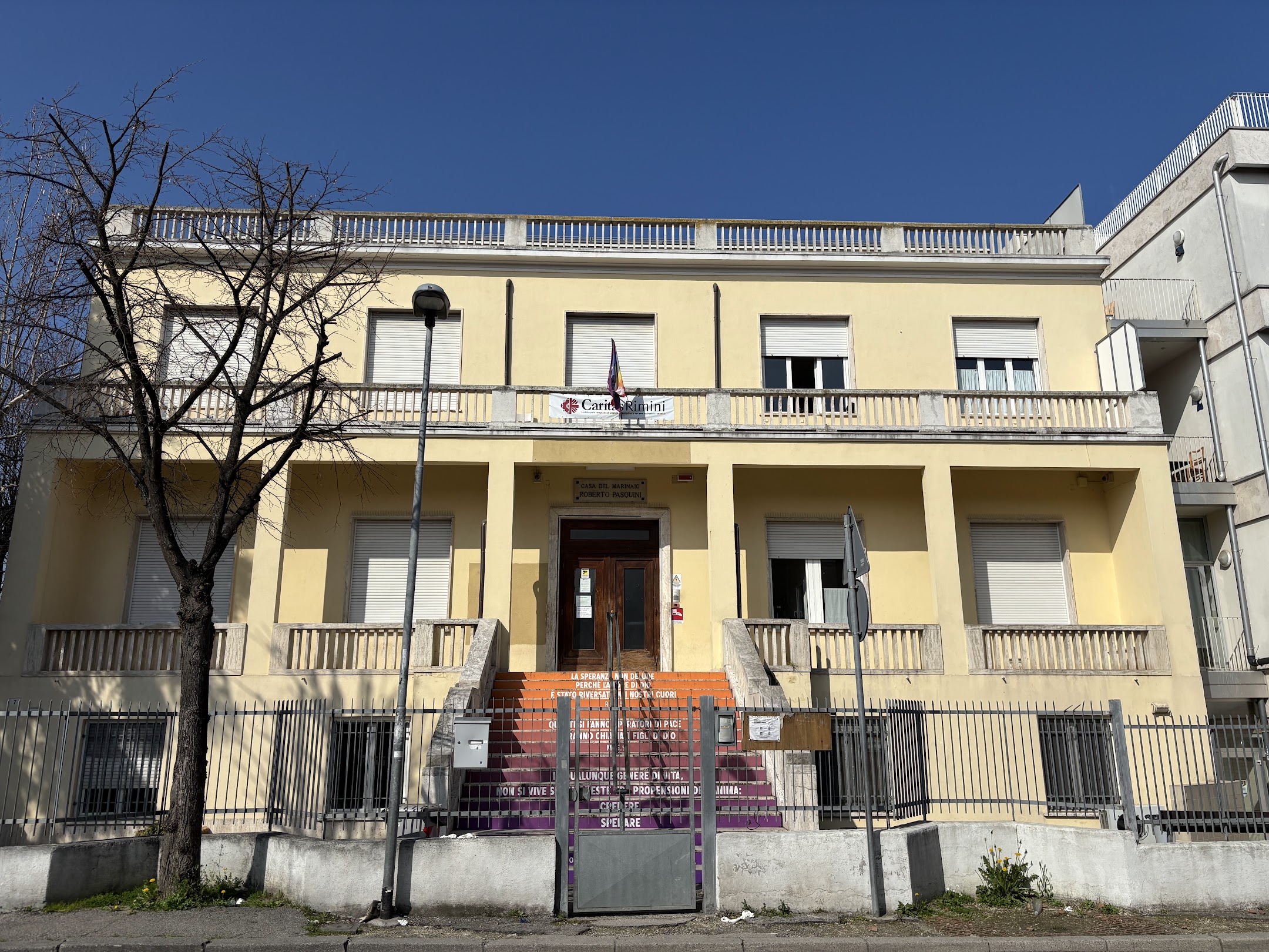 L'ingresso della Caritas di Rimini con la scalinata colorata con le parole di Sant'Agostino