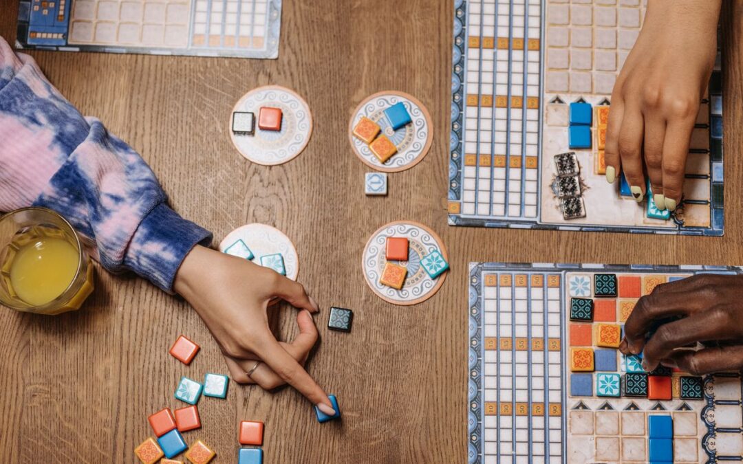 Un tavolo da gioco con pedine, dadi, cartelle e alcune mani